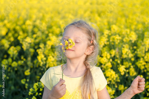charming blond girl relaxing in yellow meadow