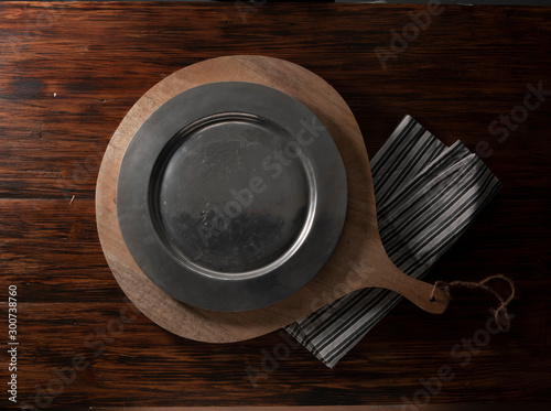 mesa y plato cenital negro sobre madera. table and black top plate on wood.