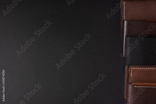 leather wallets on a black background with space for an inscription. Leather craft concept.