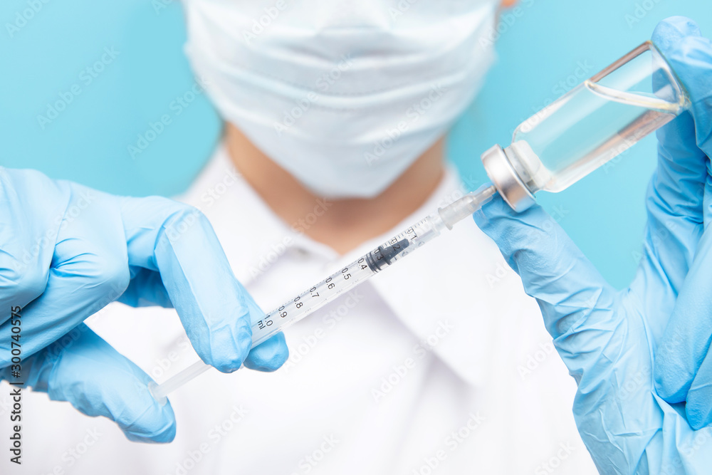 Beauty spa doctor holding syringe on blue background. Concept lip enlargement injection, anti-aging serum, plastic surgery Beauty spa doctor holding syringe on blue background. Concept lip enlargement injection, anti-aging serum, plastic surgery