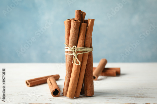Print op canvas Cinnamon sticks on white wooden background, space for text