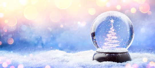 Shiny Christmas Tree In Snow Globe On Snow With Golden Lights
