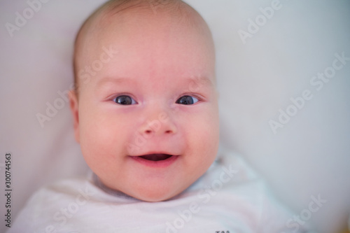  Portrait of a three-month baby. Child looking at the camera and smiling