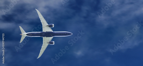 Commercial passenger jet airplane flying at the blue sky