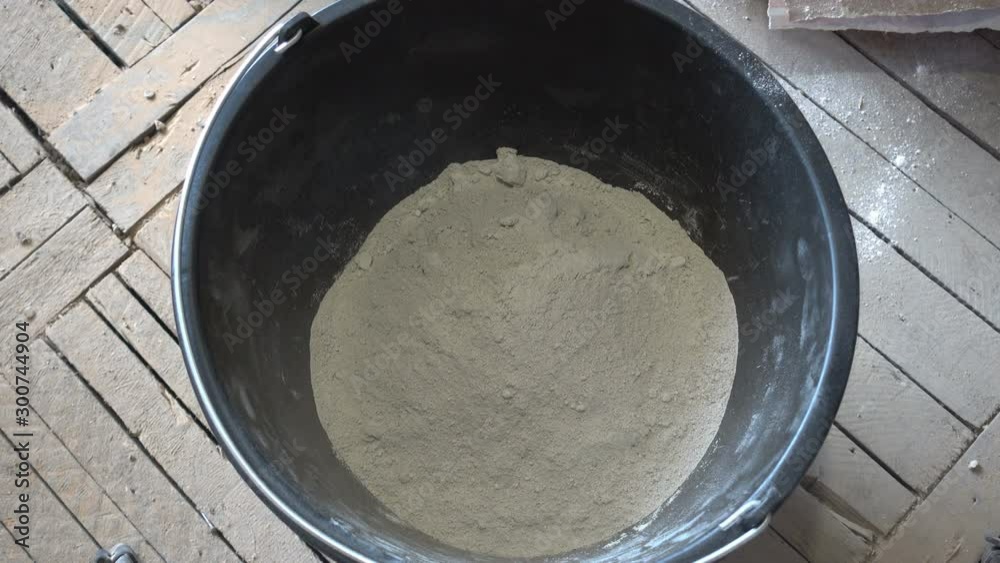 Stop motion.The builder masonry trowel the dry construction mixture into the vessel for kneading with a manual mixer.Shot in 4K UHD Stop motion.The builder masonry trowel the dry construction mixture into the vessel for kneading with a manual mixer.Shot in 4K UHD