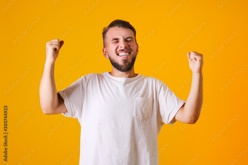 Fototapeta premium Young handsome man with facial hair posing yellow gray wall with a lot of copy space for text. Portrait of confident bearded male, wearing blank white oversized t-shirt. Isolated, background.