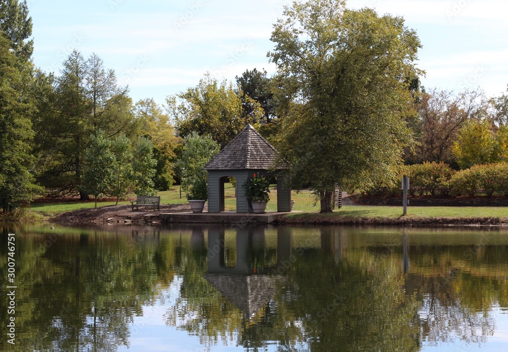 The gazebo and trees reflect off the water of the lake. The gazebo and trees reflect off the water of the lake.