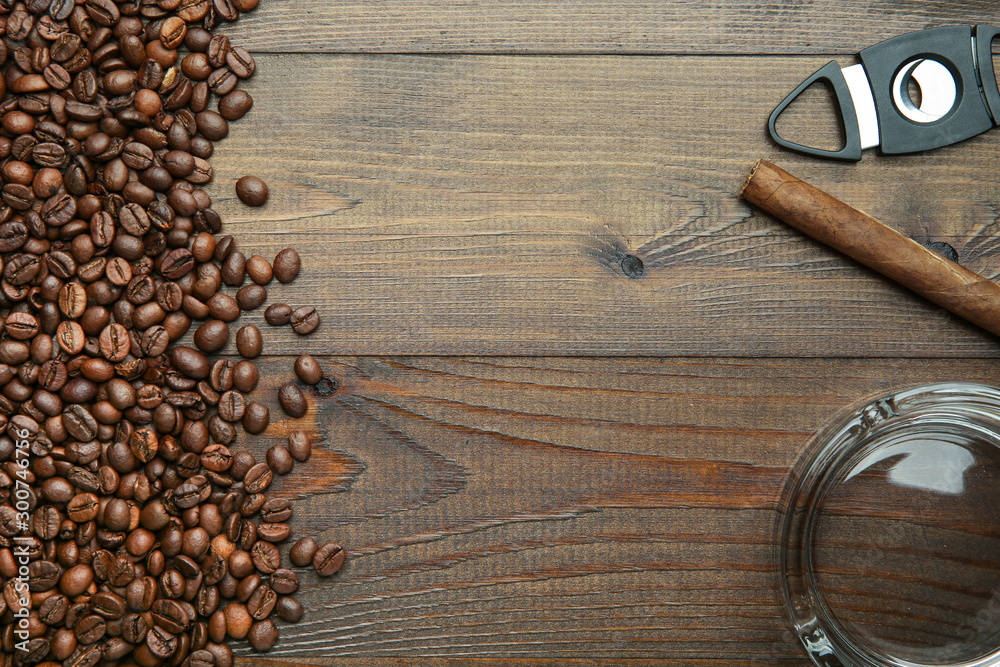 cigar, coffee beans, ashtray and cigar guillotine on wooden background with copy space cigar, coffee beans, ashtray and cigar guillotine on wooden background with copy space
