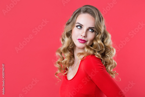 Closeup portrait of a beautiful woman with curly hair on a red background.