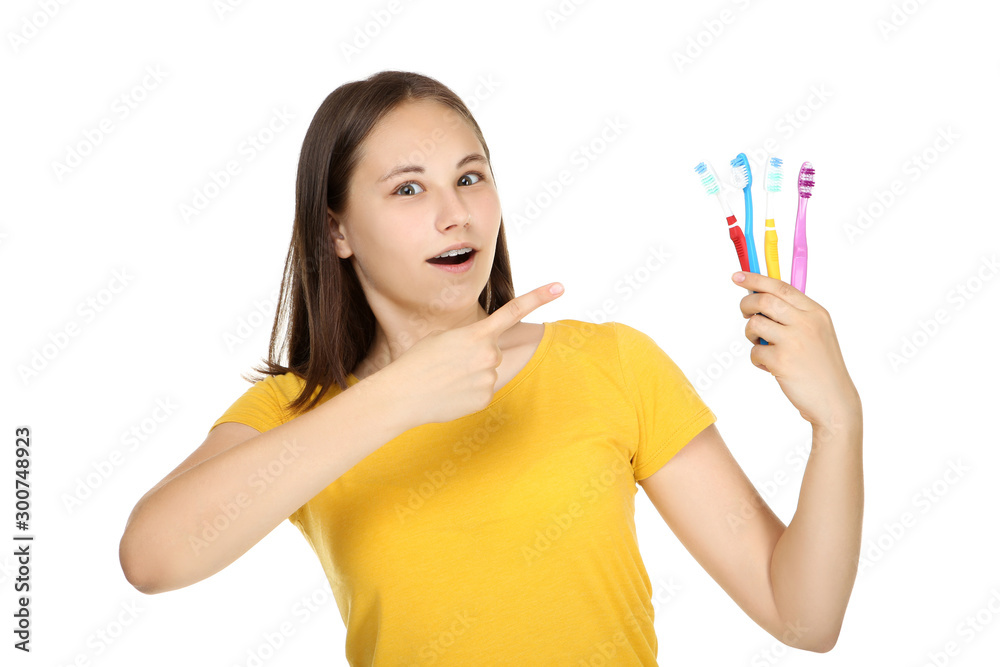 Young girl holding toothbrushes on white background