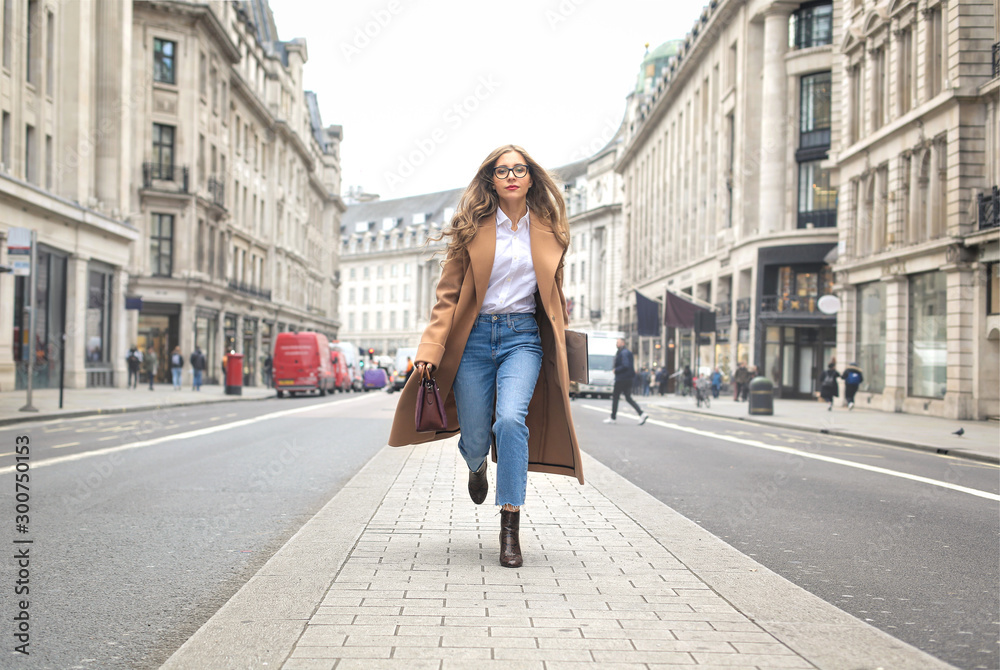 Fashionable business woman running in the street