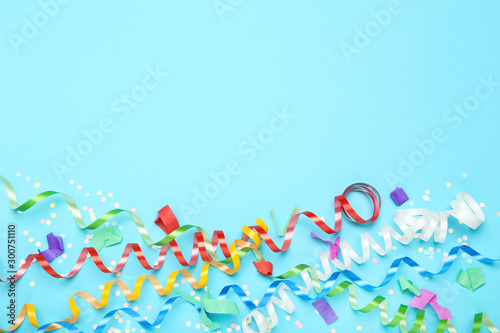 Colorful ribbons with confetti on blue background