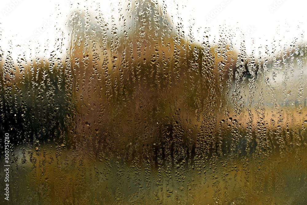 Orange tectured glass surface. Structure of water drop tracks on glazing plastic (pvc) window. Grunge pattern for texture background. Condensation drip due to bad ventilation inside house.