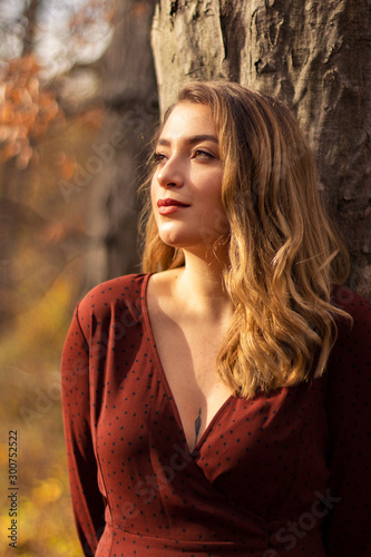 Young female model in the forest. Autumn with worm lights