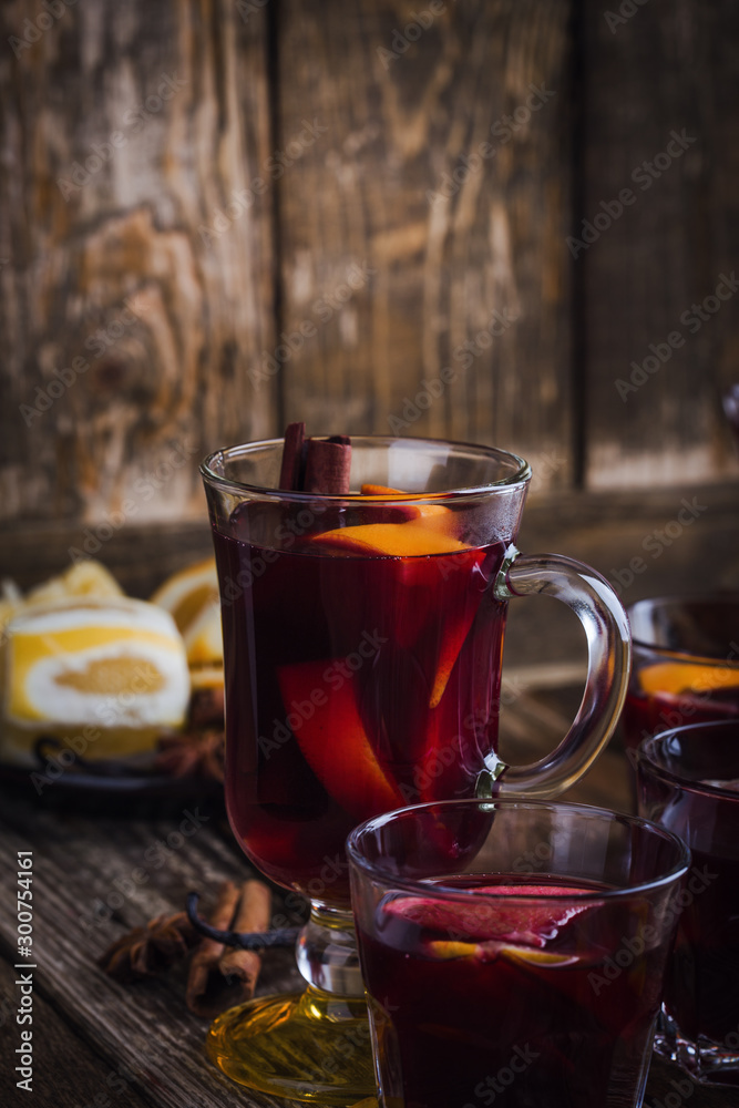 Christmas mulled wine with spices and oranges on wooden table, hot drinks Christmas mulled wine with spices and oranges on wooden table, hot drinks