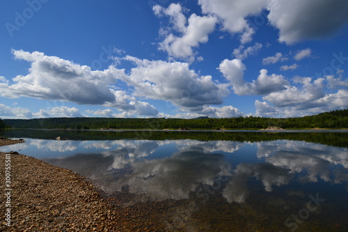 Mysterious north river Vishera lies beneath the clouds and blue sky and flows to south