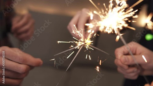 Footage of male and female hands trying to fire up bengal lights standing around making circle. Cropped shot of bengal fire sticks, sparkling, burning, friends together holding fire-sticks