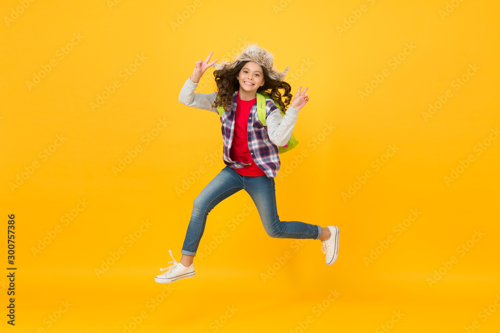 Captured in motion. Winter season concept. Kid girl wear hat with ear flaps. Winter vacations. Winter events at school. Winter entertainment and activities. Child schoolgirl soft hat enjoy season