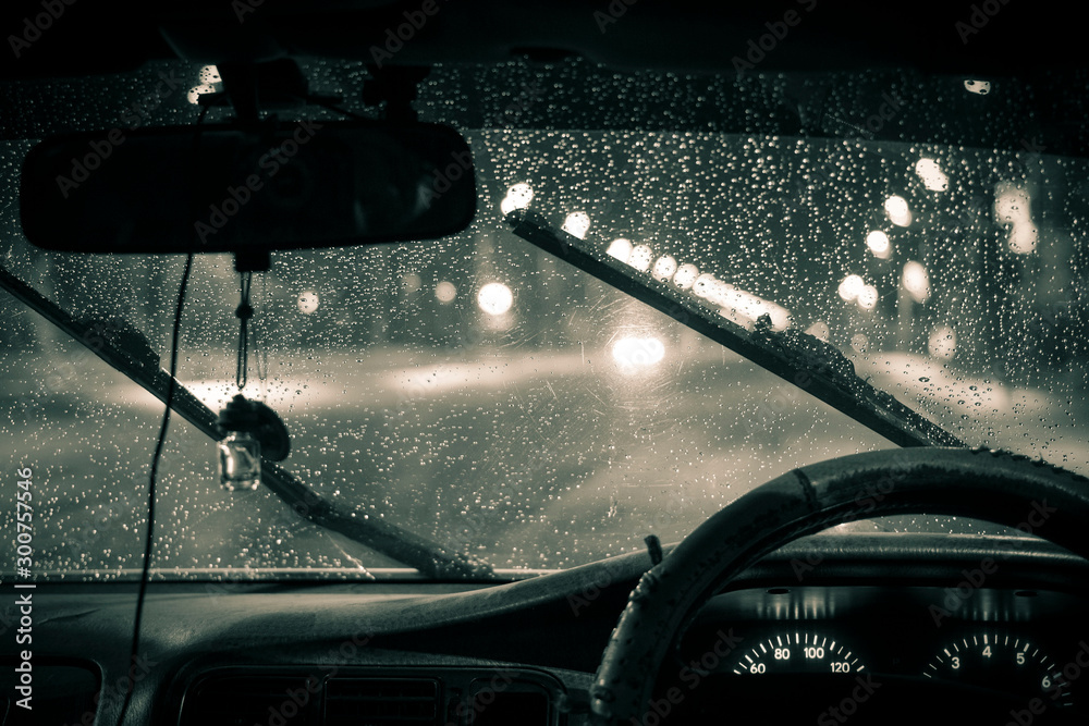 car windshield wipers in rainy season, black and white photo with vignetting, front and rear background blurred with bokeh effect - obrazy, fototapety, plakaty 