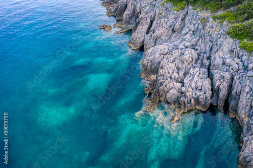 Aerial view of Trsteno beach in Montenegro, near Budva, in a beautiful bay with a rocky shore, blue water © Alexey Oblov
