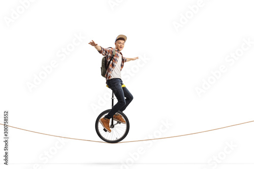 Male teenager riding a unicycle photo