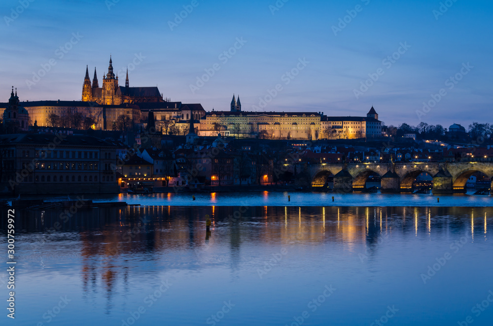 The night begin to fall over the city and the city lights reflect over the Moldava river, Prague, Czech Republic