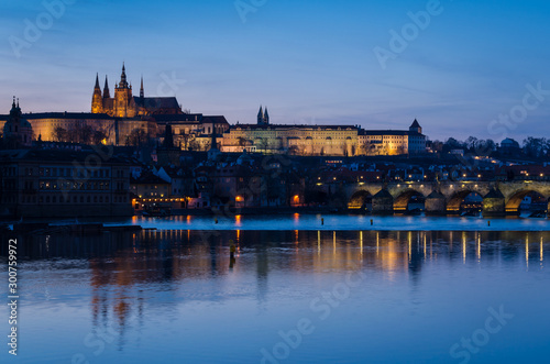 The night begin to fall over the city and the city lights reflect over the Moldava river, Prague, Czech Republic