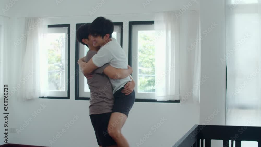 Young Asian Gay couple feeling funny active having fun dancing together at home. Cheerful Asia LGBTQ+ men enjoy moving to music spending weekend time in living room at modern house in morning concept. Young Asian Gay couple feeling funny active having fun dancing together at home. Cheerful Asia LGBTQ+ men enjoy moving to music spending weekend time in living room at modern house in morning concept.