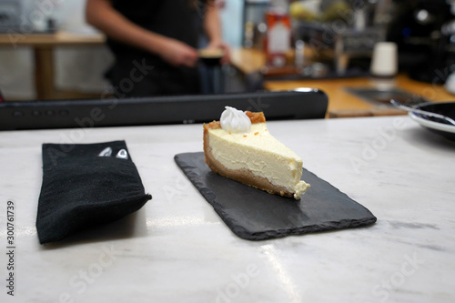  cheesecake on the table in the cafe. in the background the barista is carrying coffee. Selective focus