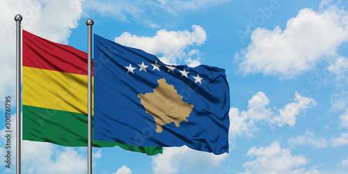 Bolivia and Kosovo flag waving in the wind against white cloudy blue sky together. Diplomacy concept, international relations.