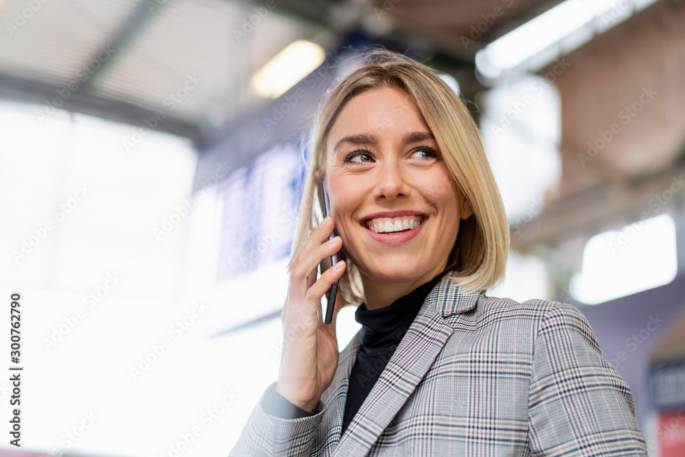 Happy young businesswoman on the phone at the train station Happy young businesswoman on the phone at the train station