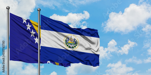 Bosnia Herzegovina and El Salvador flag waving in the wind against white cloudy blue sky together. Diplomacy concept, international relations.