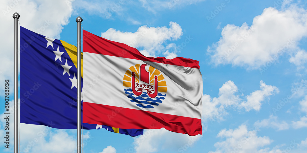 Bosnia Herzegovina and French Polynesia flag waving in the wind against white cloudy blue sky together. Diplomacy concept, international relations.