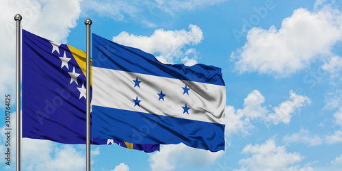 Bosnia Herzegovina and Honduras flag waving in the wind against white cloudy blue sky together. Diplomacy concept, international relations.