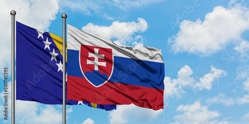 Bosnia Herzegovina and Slovakia flag waving in the wind against white cloudy blue sky together. Diplomacy concept, international relations.