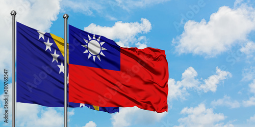 Bosnia Herzegovina and Taiwan flag waving in the wind against white cloudy blue sky together. Diplomacy concept, international relations.