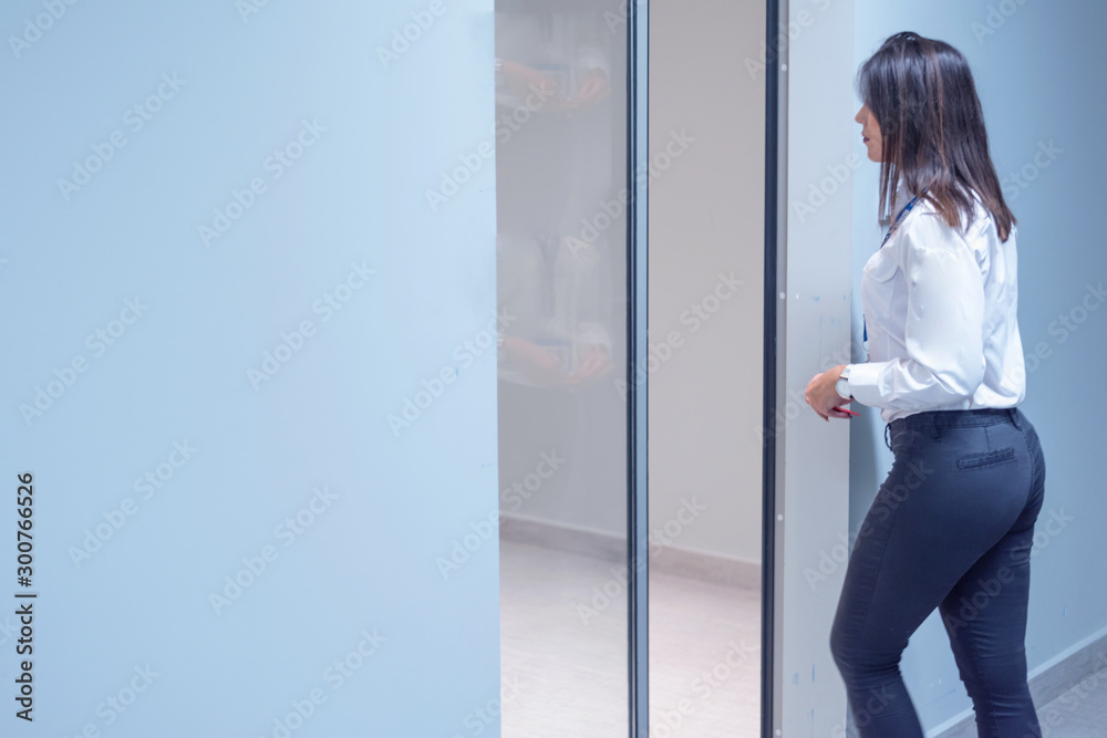 Businesswoman bank employee  bank vault door opening and going inside.