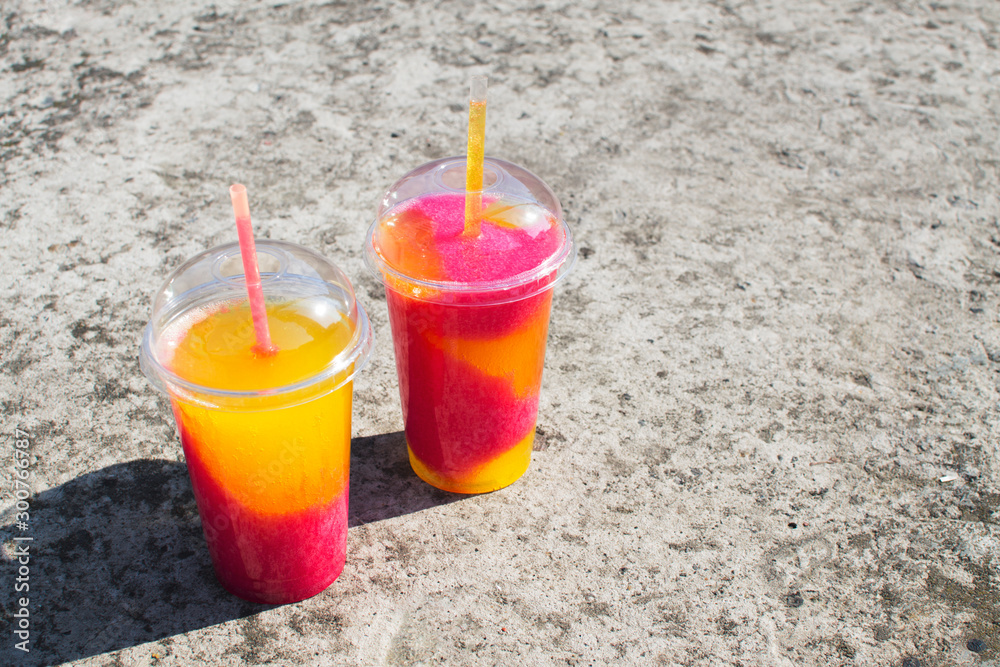 Multicolored fruit cocktail of crushed frozen ice on a concrete background. Place for text