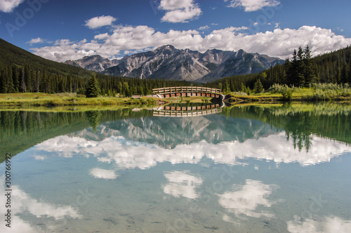 Cascade Pond with foot bridge and mountains reflecting in pond in Banff National Park, Alberta, Canada