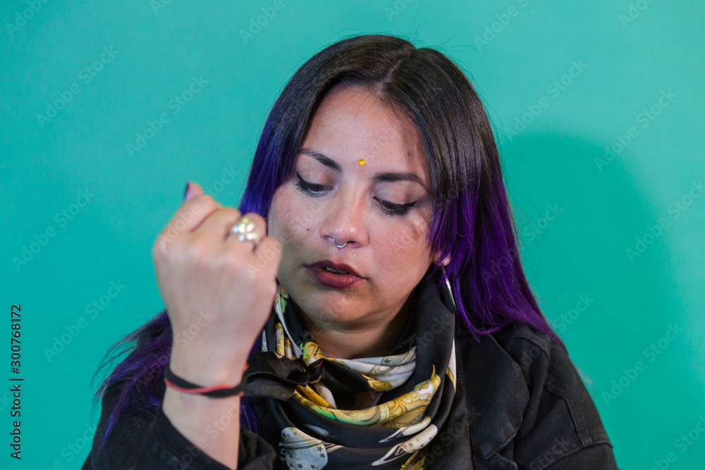 Obraz premium Latin woman singing with an acoustic guitar on green background
