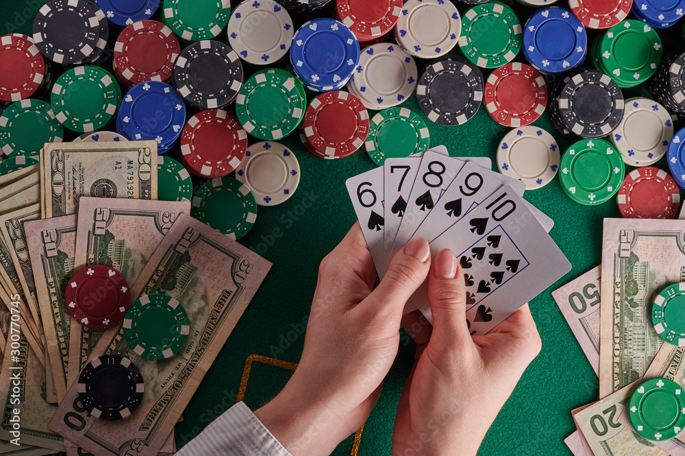 A player in a poker casino shows cards with a combination of straight on  the background of chips and money of dollars. Victory, success. Gaming  business. Stock Photo | Adobe Stock