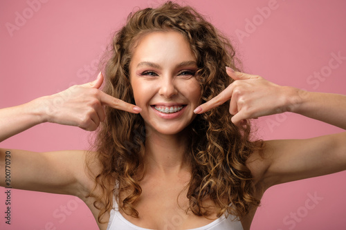 Happy girl with curly hair and dental braces photo