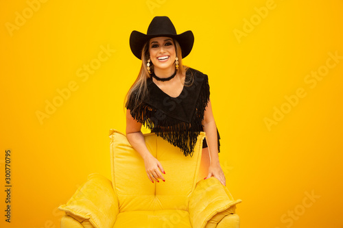 Happy sexy cowgirl on yellow background