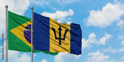 Brazil and Barbados flag waving in the wind against white cloudy blue sky together. Diplomacy concept, international relations.