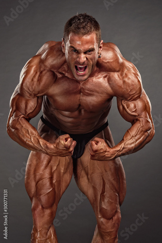 Foto Bodybuilding Competitor Posing and Flexing Muscles