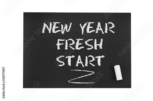 Inscription in chalk on black paper: New year, fresh start. The concept of life from scratch, a new period in life, renewal, fresh solutions, new beginnings and opportunities.