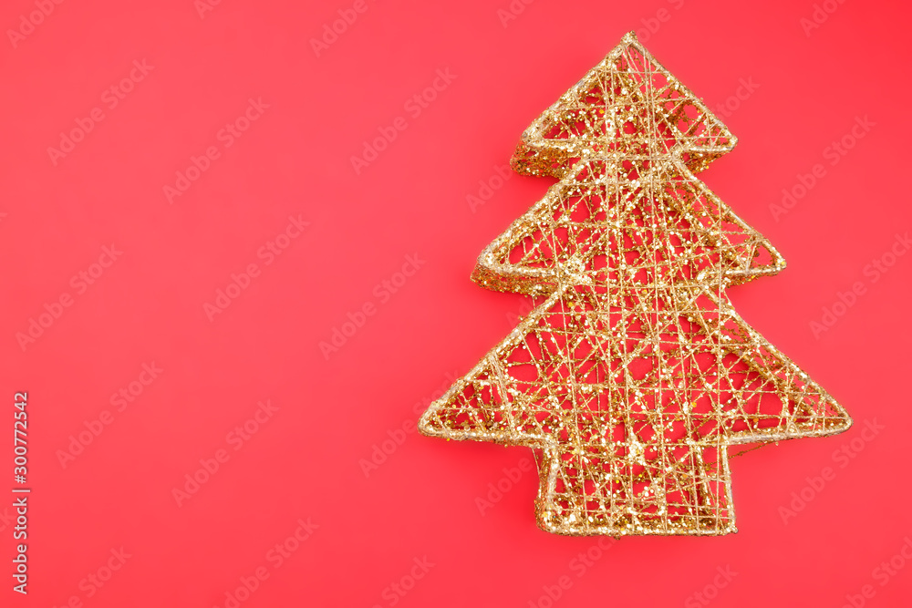 Openwork metal Christmas tree on a red background. Element of Christmas and New year decor. Close up. Openwork metal Christmas tree on a red background. Element of Christmas and New year decor. Close up.