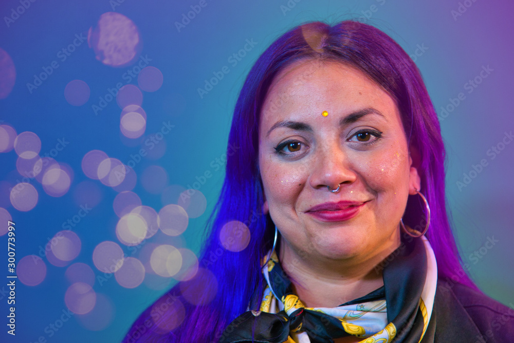 portrait of latin woman blue and purple painted hair with purple background and light sparkles portrait of latin woman blue and purple painted hair with purple background and light sparkles