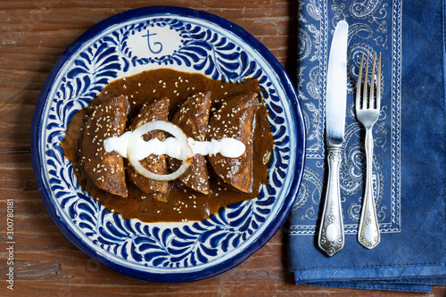 Fototapeta Naklejka Na Ścianę i Meble -  Mole enchiladas traditional mexican dish in a talavera plate