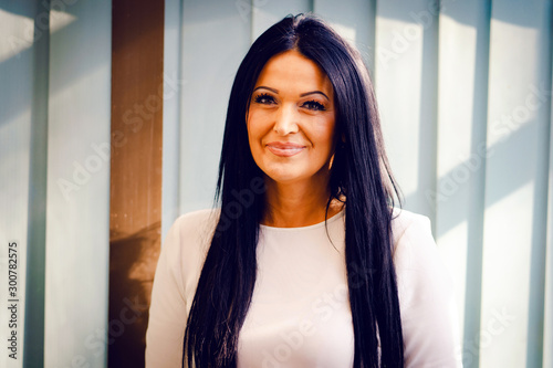 Free Download Portrait of a caucasian woman in white sweater and black hair standing in front of the window - GFXLoad